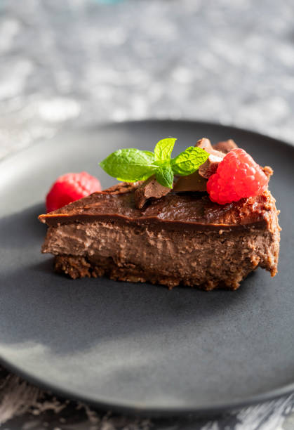 istock delicious sweet chocolate cheesecake cake in a restaurant with raspberries and mint leaf on a plate 1425614794