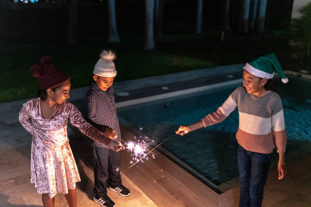 istock Siblings playing on christmas with sparklers outdoors 1425615601