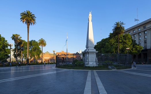 Buenos Aires, Argentina, November 19, 2019: View of the Plaza de Mayo with the Pirámide de Mayo and the presidential palace Casa Rosada in the background at sunset.