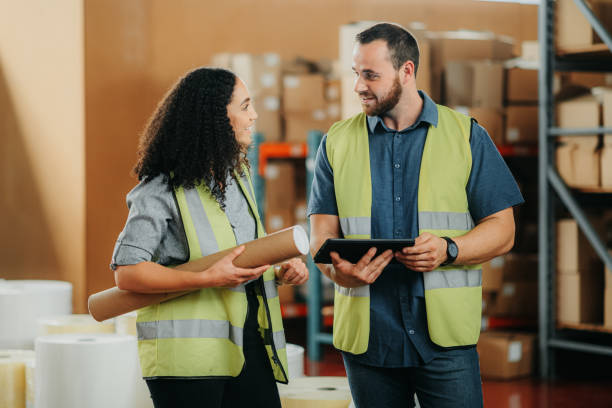 istock Logistics worker, employee and people planning cargo stock on tablet working at a distribution warehouse, talking about delivery and building project at work. Happy people at factory for freight 1425618074