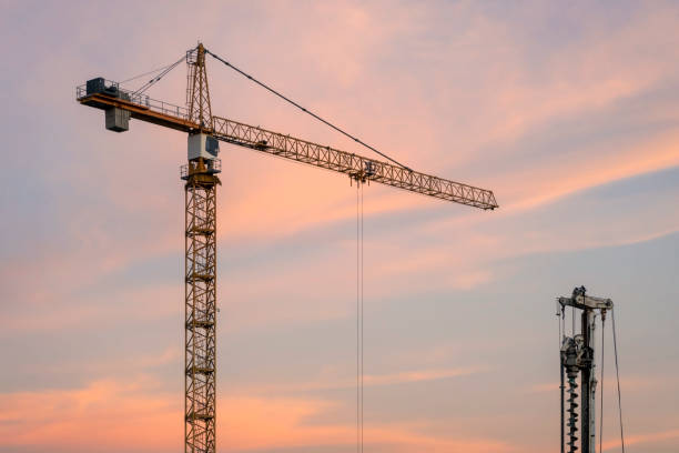 istock Construction equipment against sunset sky. Red tower crane. 1425618201