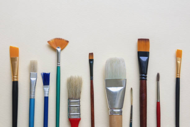 istock Different artistic paint brushes on paper background. Free space for text 1425618790