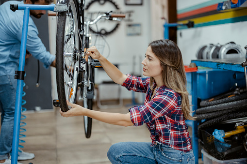 Two mechanics fixing bicycle's in a workshop
