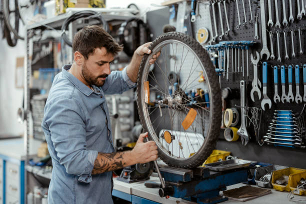 Shot of a young man working in a bicycle repair shop