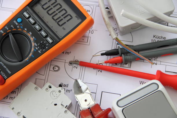 Sockets with a screwdriver and a measuring device on a circuit diagram on a table is a measuring device with a circuit diagram and test prods and sockets with a screwdriver electrician multimeter stock pictures, royalty-free photos & images
