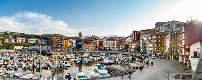 Panoramic view of Bermeo. In first plan view of the fishing harbour, with small boats and yachts docked. In background the city with the promenade area of the harbour.