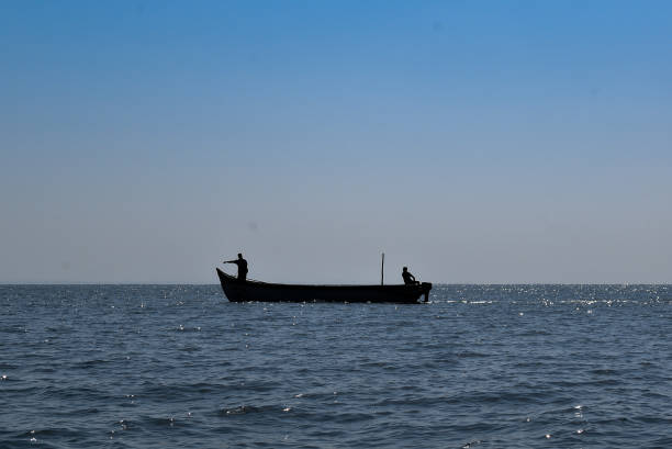 Fishermen venture into the sea with clear blue skies