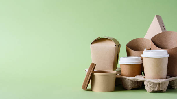 istock Paper disposable tableware and packaging for fast food on a green background. Free empty space on the left. 1425635069