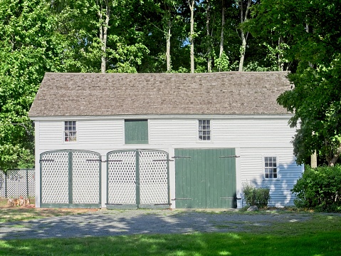 Old horse barn and stables near Lexington battlefield, Lexington Massachusetts, September 2022. Old white barn with green door from the colonial time period.