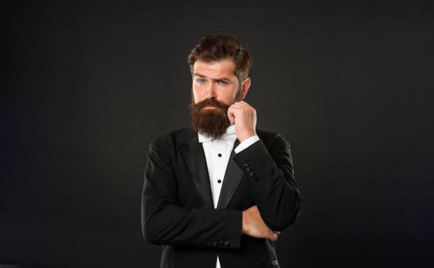 istock bearded groom in tuxedo on black background, tux 1425638178