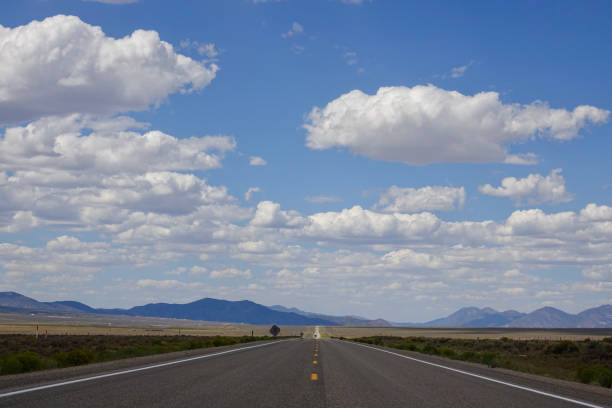 Open road through the desert with cloudy skies