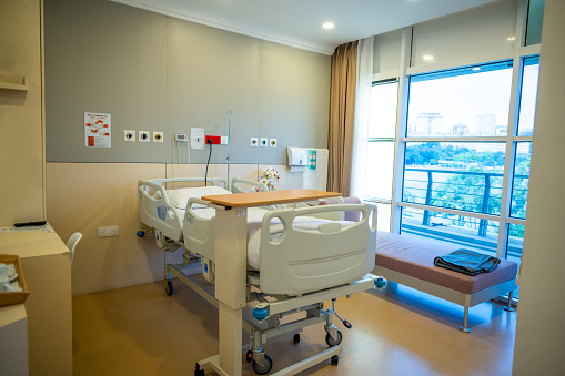Interior of a modern luxury hospital room with outdoor city view.
