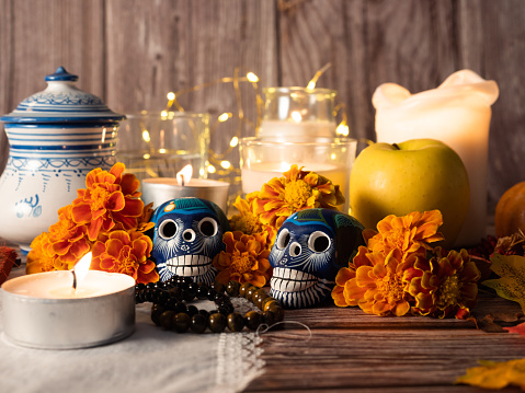 Mexican traditional autumn festival day of the dead typical  skull  painted on wood background , marigold flowers and candle