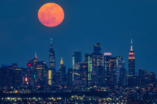 The Pink Full Moon rises over One Vanderbilt with the Empire State and Chrysler buildings in the shot