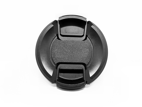 Black lens cap placed, isolated on a white background.