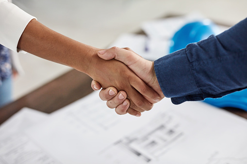 Architecture, b2b and partnership handshake or shaking hands after industrial contract agreement in office meeting. Collaboration, teamwork and company workers welcome new corporate industry deal