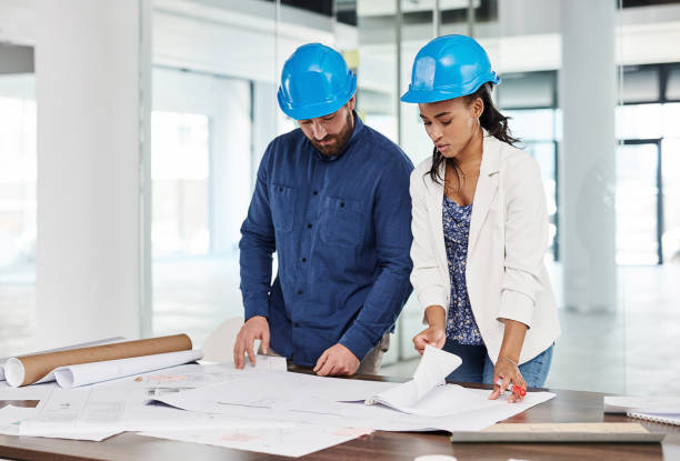 istock Architects, construction workers and employees planning building project with blueprint, in conversation about home renovation plan and collaboration for maintenance. Design team thinking of ideas 1425656795