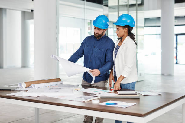 istock Architect, construction or design with an engineer and building designer looking at a blueprint in an office at work. Architecture with a builder and contractor working as a team and planning a build 1425656905