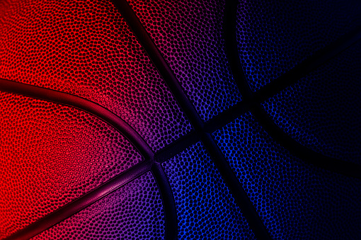 Closeup detail of basketball ball texture background. Neon banner art concept. Horizontal sport theme poster, greeting cards, headers, website and app