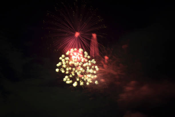 Aerial view of bright fireworks exploding with colorful lights against dark night sky on US Independence day holiday.