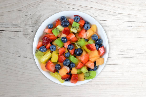 istock Fresh Cut Fruit Salad on a White Wood Background 1425661247