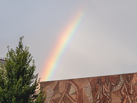 Moscow, Russia - September 17, 2022.Bright and colorful rainbow in the air. Cloudscape after rainfall over old cinema Oktyabr.