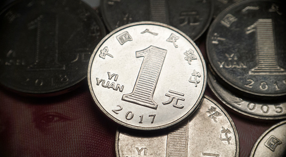 Close-up of a Chinese one yuan coin. Lots of 1 yuan coins in the background. Close-up of a one yuan coin minted in 2017