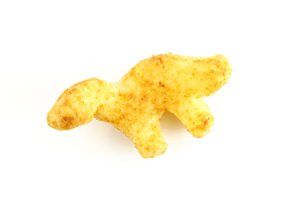 istock Dinosaur shaped peanut flips puff isolated on white background. Kids food 1425663881
