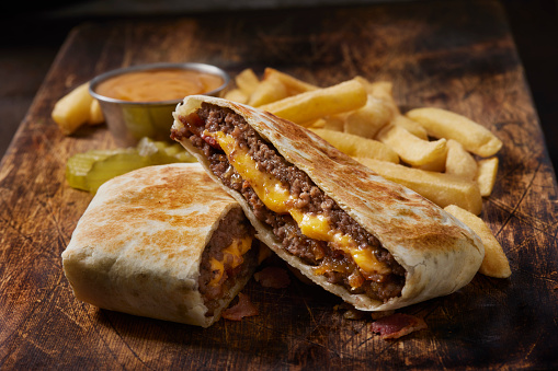 Double Bacon Cheese Burger Crunch  Wrap with Caramelized Onions, Chipotle  Crema and 
Fries
