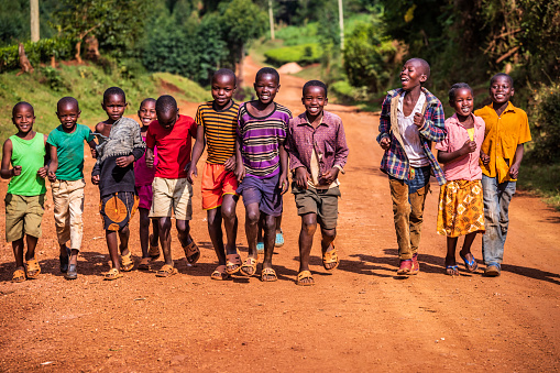 Group of colorful dressed, happy African children running in Central Kenya, East Africa