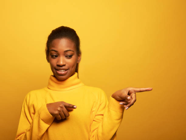 istock Amazed Afro woman points away on copy space, discusses amazing promo 1425692696