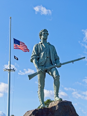 The minuteman statue stands proud over Lexington battlefield green, September 2022. The bronze statue memorializes the men who fought here at the start of the American revolution April 19 1775.
