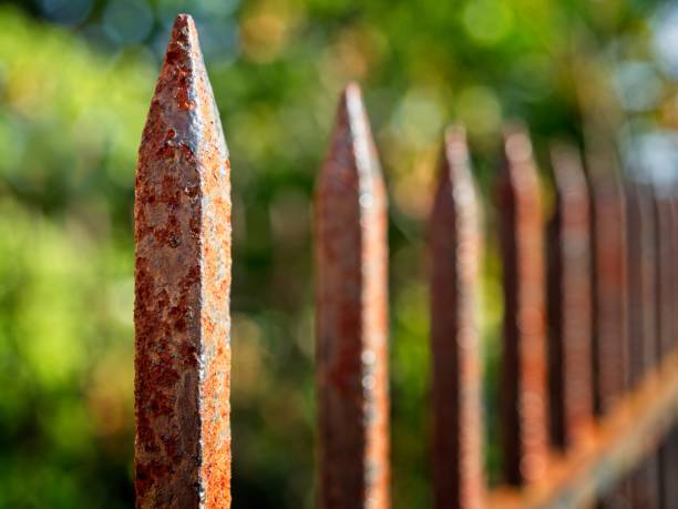 Rusty spires on an old wrought iron fence with selective focus. The fence surrounds the historic replica belfry in Lexington Massachusetts.