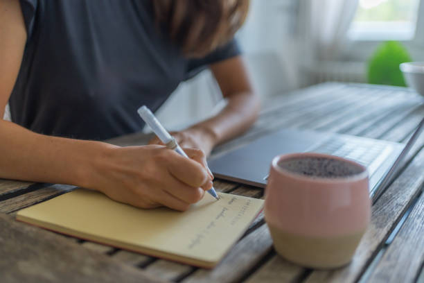 istock Young woman works at dining room table 1425694695
