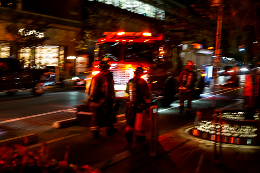 Firefighters in action at night and in blurred motion