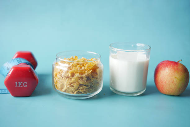 morning cereal , milk, apple and dumbbell on blue ,