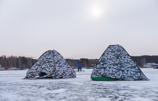 Novosibirsk Russia - March 13, 2020: Winter fishing in Siberia - fisher's tents on ice of Ob reservoir in Novosibirsk, Siberia, Russia