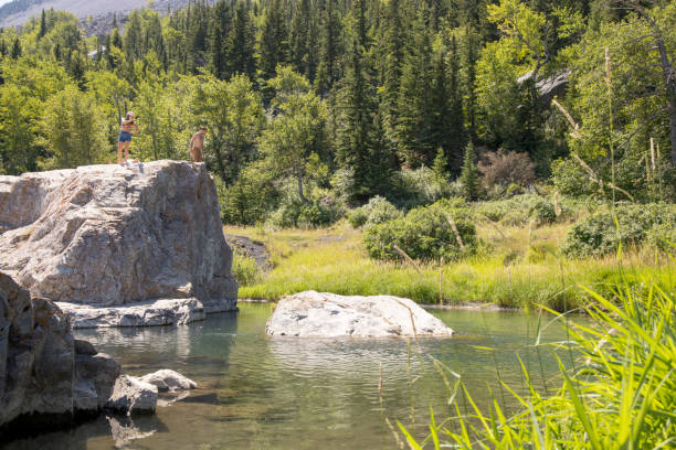 istock Couple approach cliff edge to jump into river below 1425709954