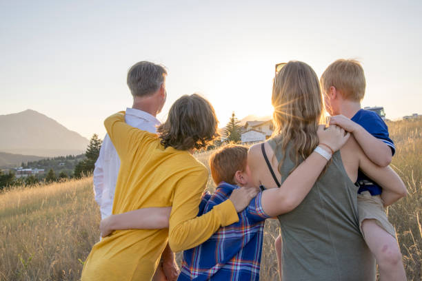 istock Young family in mountain meadow at sunset 1425710294