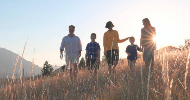 istock Young family in mountain meadow at sunset 1425710327