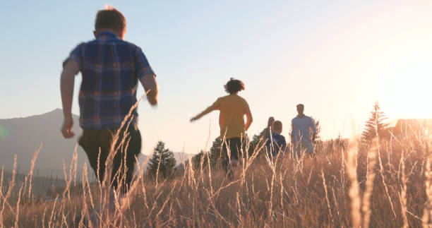 istock Young family in mountain meadow at sunset 1425710331