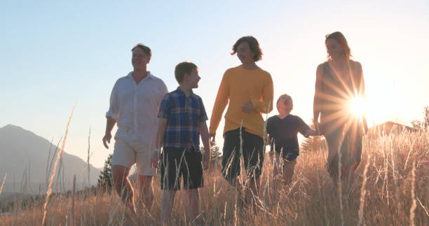 istock Young family in mountain meadow at sunset 1425710338
