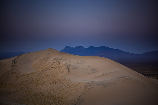 Sand dunes in Mojave National Preserve in California. The preserve was established to protect nature and local animal species. This image is part of a series of views taken at different times of day from the same location; a time lapse is also available.