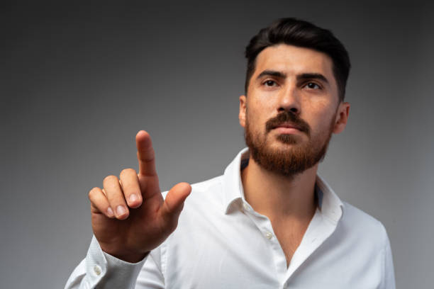 istock Young Arab businessman working with virtual screen over grey background. 1425719978