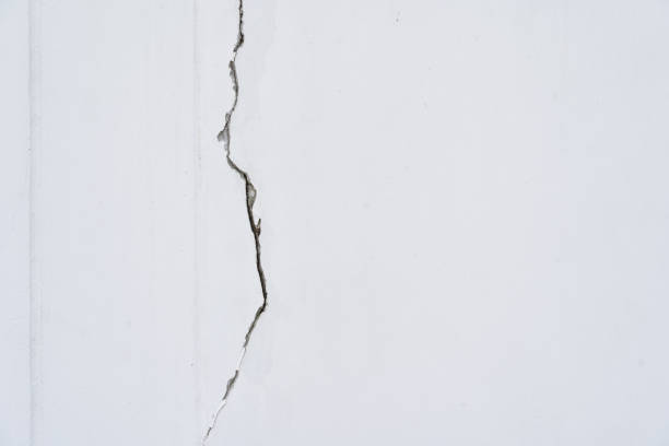 house broken. concrete crack. Water damage building interior. large crack white concrete wall