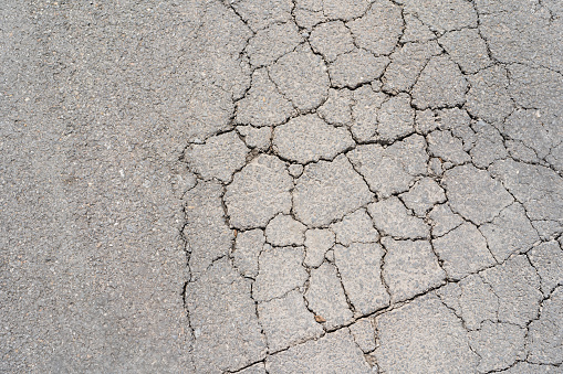 closeup of cracks on asphalt road. Old worn and cracked asphalt with cracks
