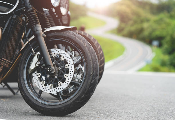 moto dans une moto ensoleillée sur la route roulant.avec la lumière du coucher du soleil. espace de copie pour votre texte individuel. moto triumph. - motorcycle engine brake wheel photos et images de collection