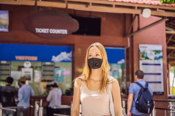 istock young woman wearing a hygiene protective mask over her face while walking at the crowded place. Healthcare and sickness prevention from coronavirus, Covid19 influenza in crowded place 1425744257