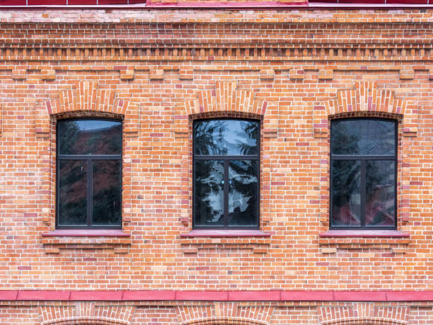 istock Three windows of the old mansion 19 century with brown bricks wall 1425745042