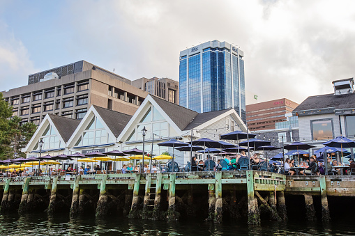 Halifax, Canada - August 30, 2022. A patio restaurant in downtown Halifax as viewed from the water on  a summer evening.